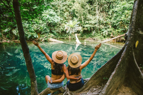 2 girls sitting by a body of water in Daintree Rainforest