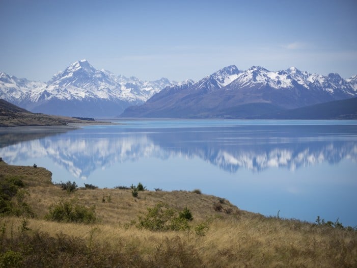 snowy mountain next to lake