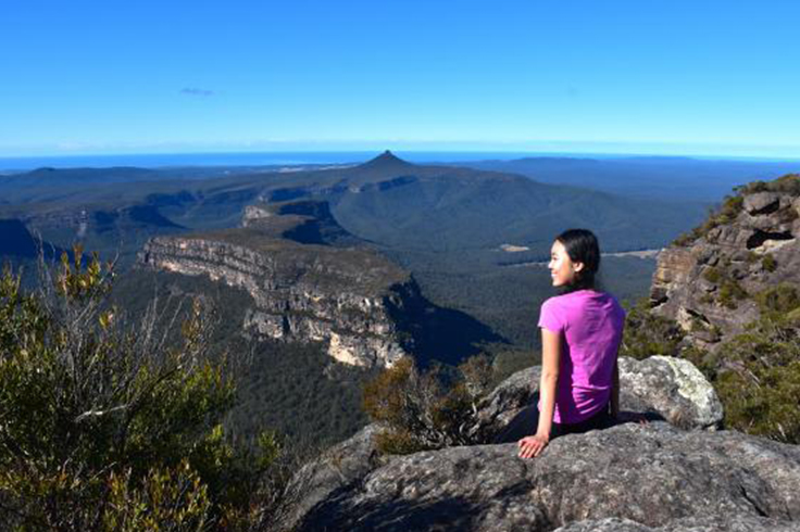 top 3 road trip worthy hikes in nsw 1 Girl looking out to a view at the top of a mountain