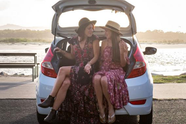 top 5 reasons to hire from jucy in australia 2 Two girls sitting in the back of a JUCY car at the beach