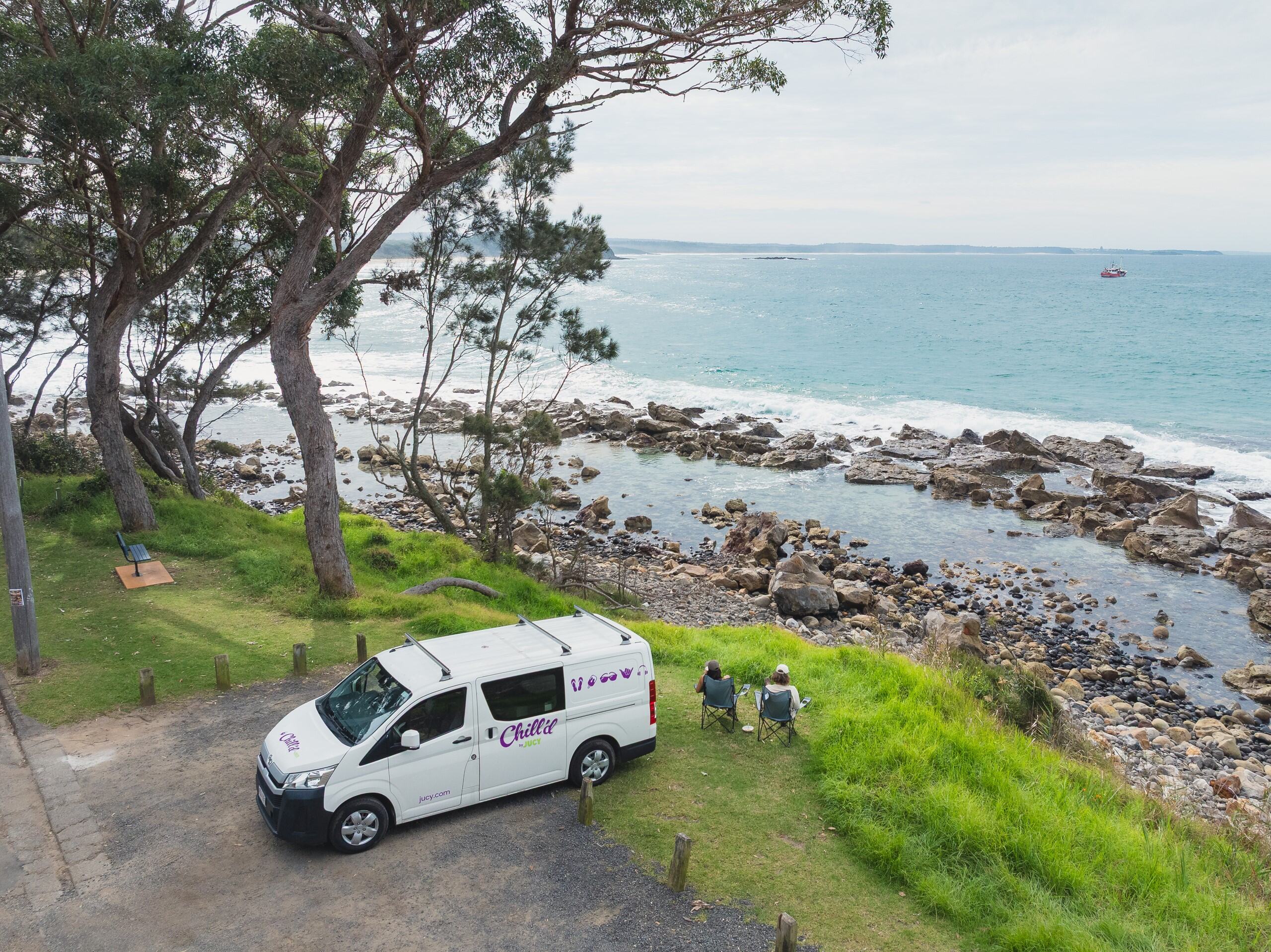 Adam and Clara Malibuy Campervan parked at rocky beach