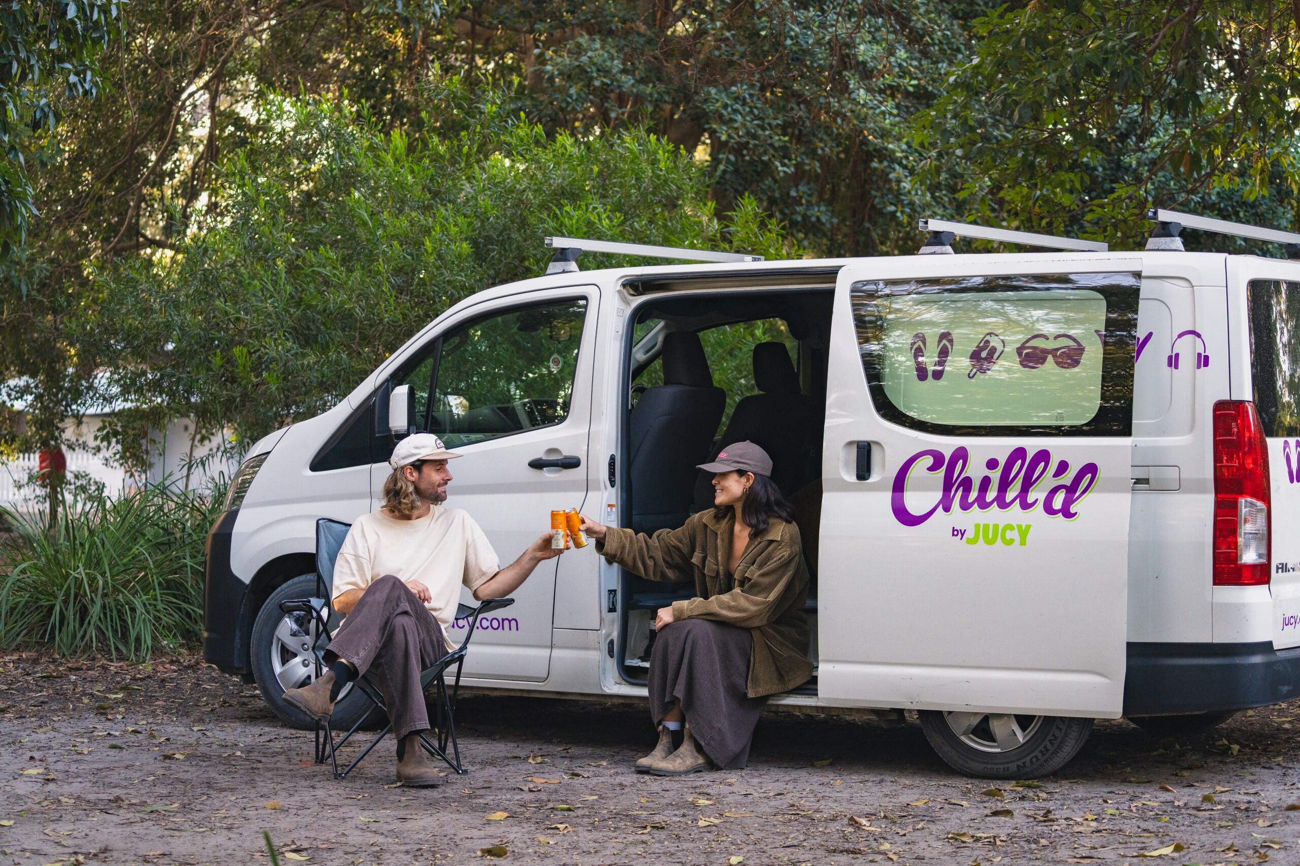 Adam and Clara enjoying drinks outside campervan at Green Patch nature park
