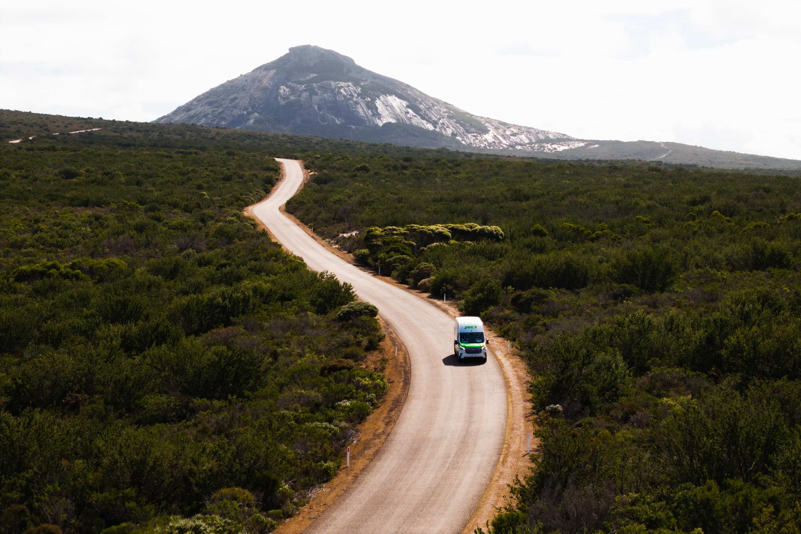 JUCY Coaster Driving though inland road near mountain