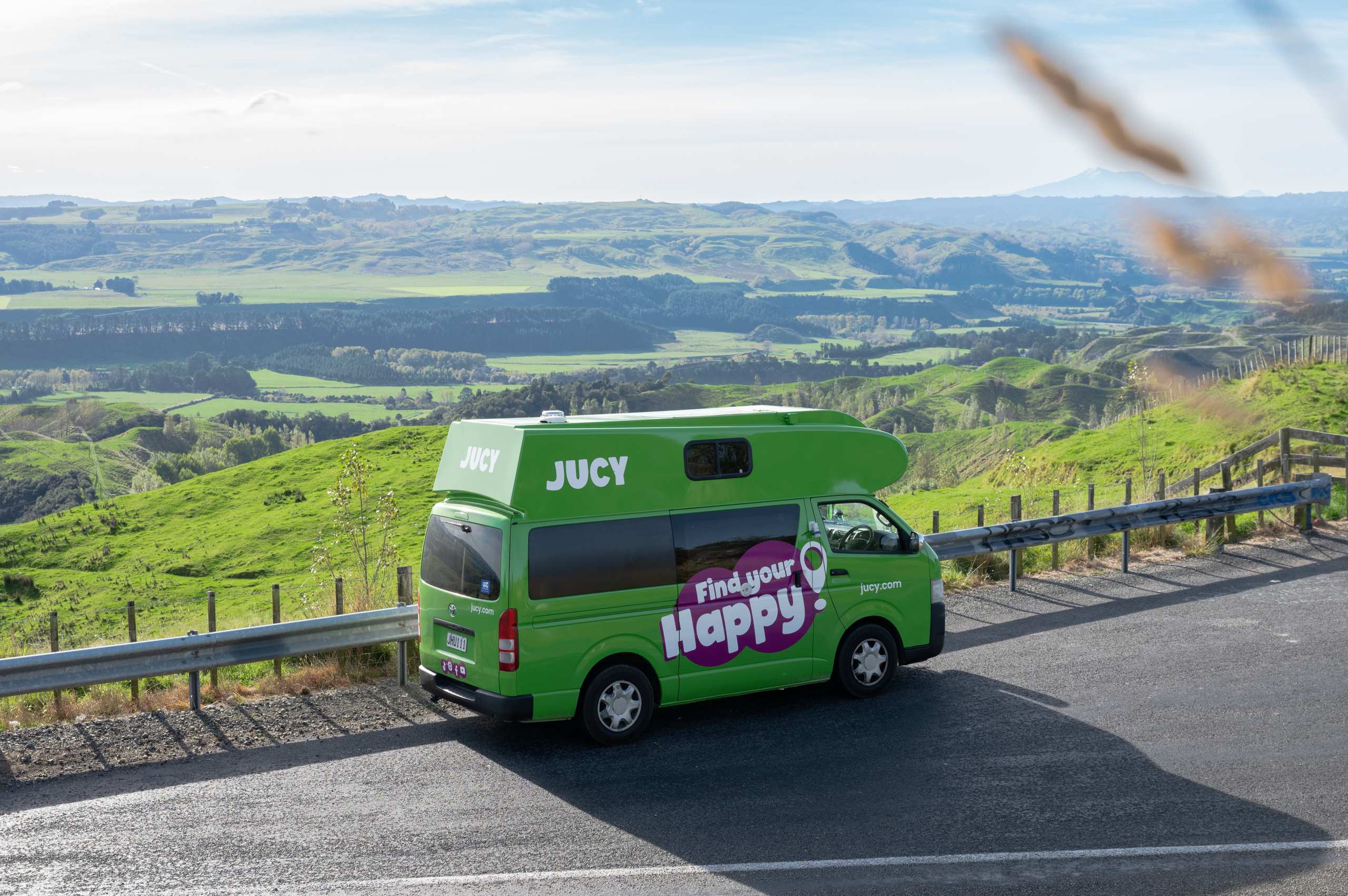 JUCY chaser parked next to scenic hillside