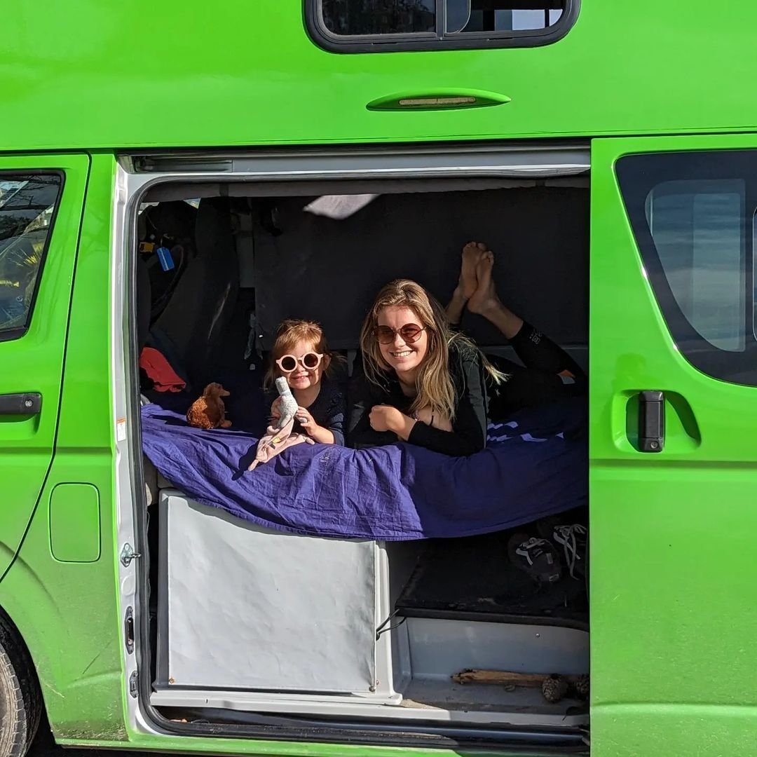 Mum and daughter relaxing inside a JUCY Condo Campervan