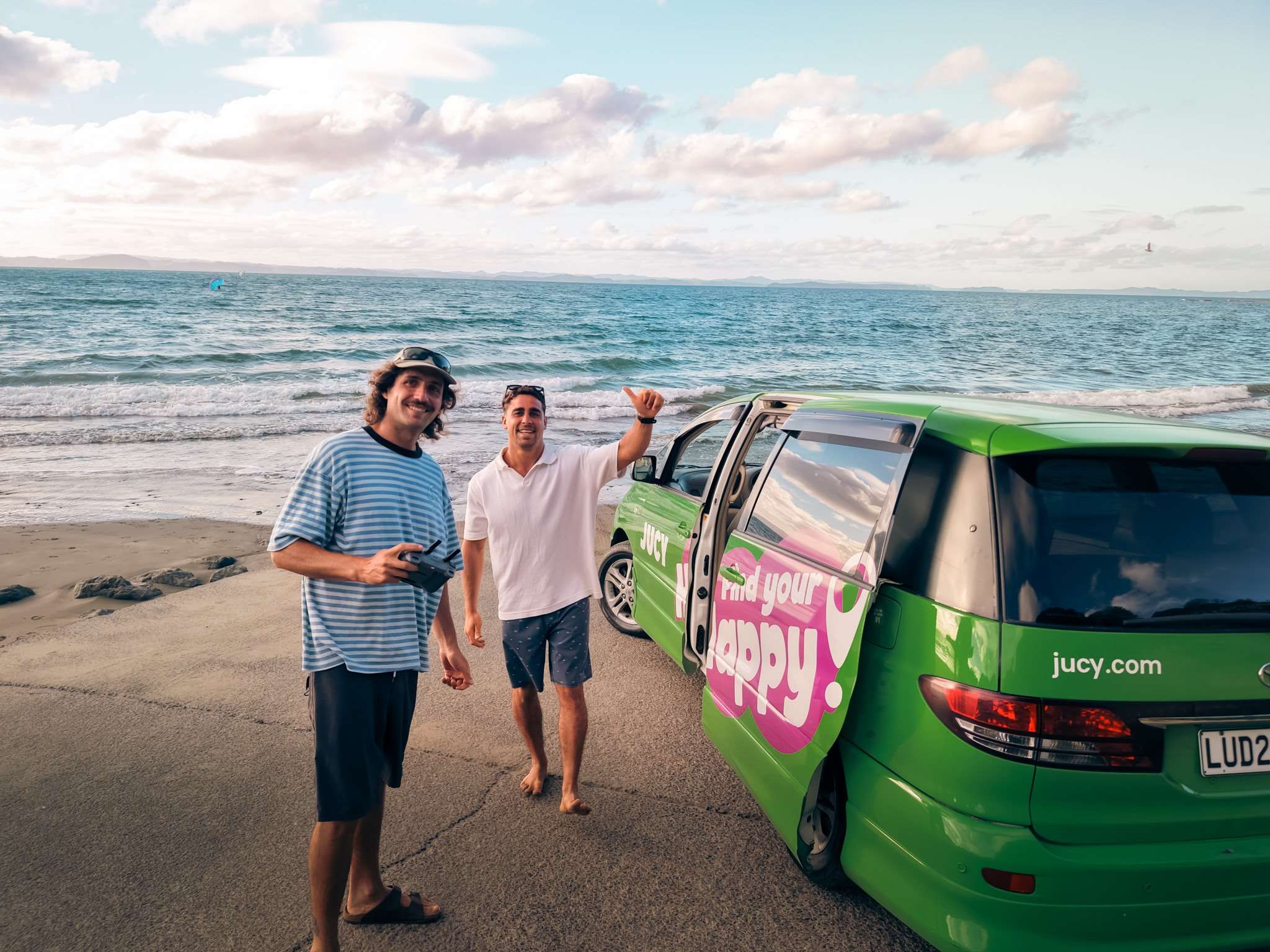 Two mates next to their Crib parked next to nz beach