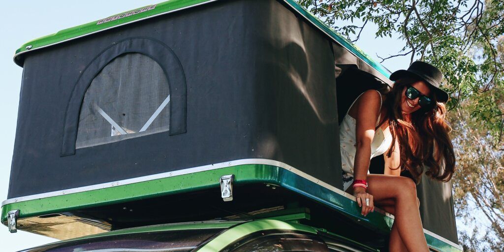 Lady climbing down from the rooftop tent of the Crib Plus Campervan