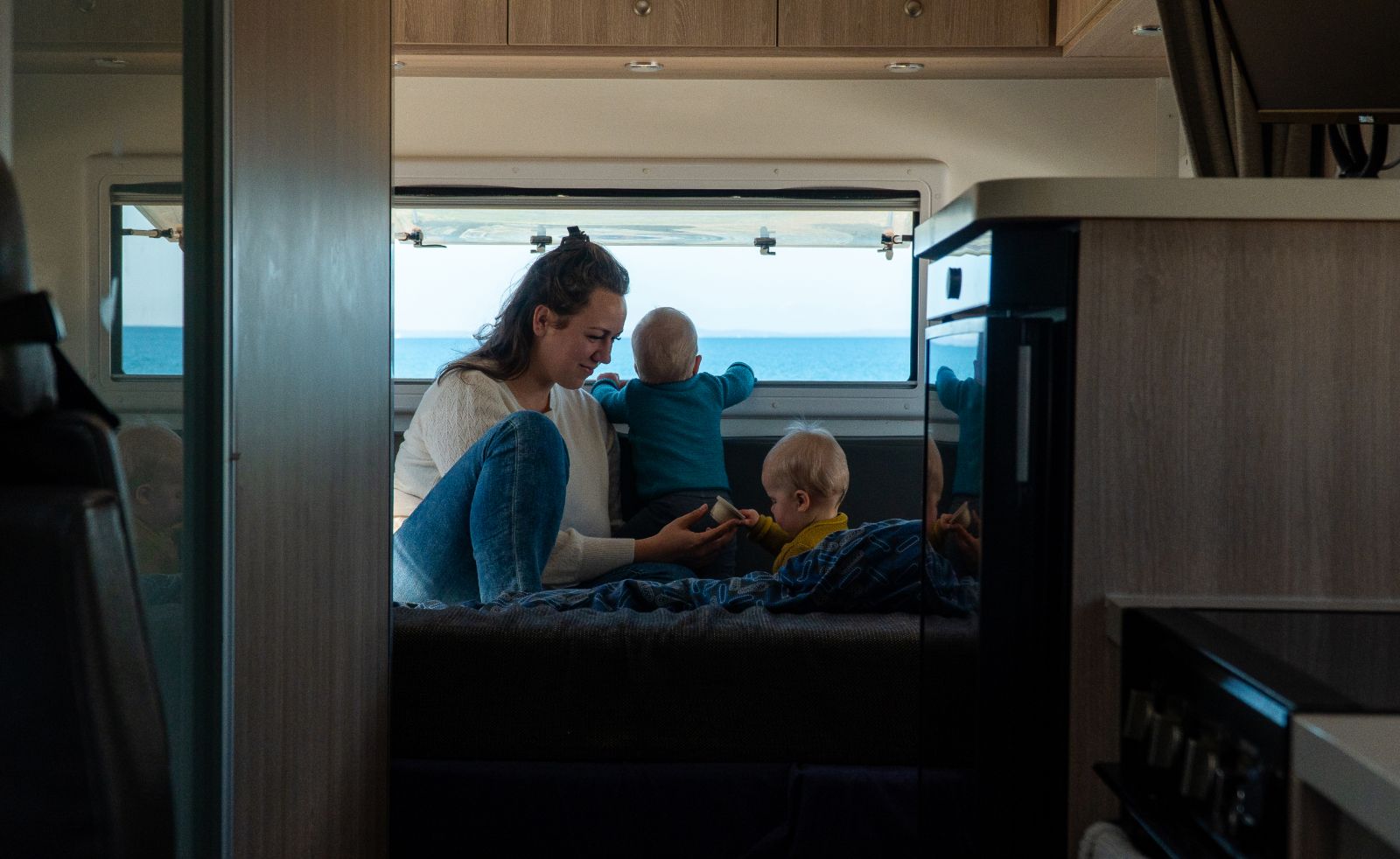 Mother and two kids playing inside the back of a Polaris 6 motorhome